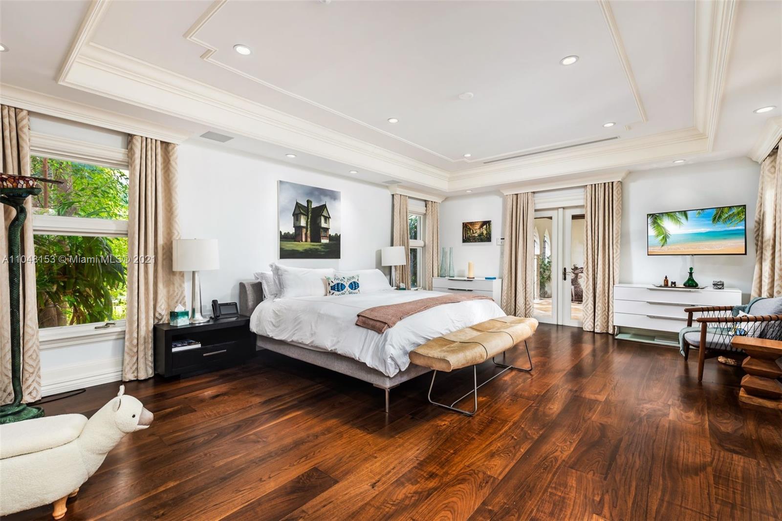 6385 Pine Tree Dr Circle Miami Beach, FL 33140 - Photo 16 of 37 a bedroom with a bed and wooden floor