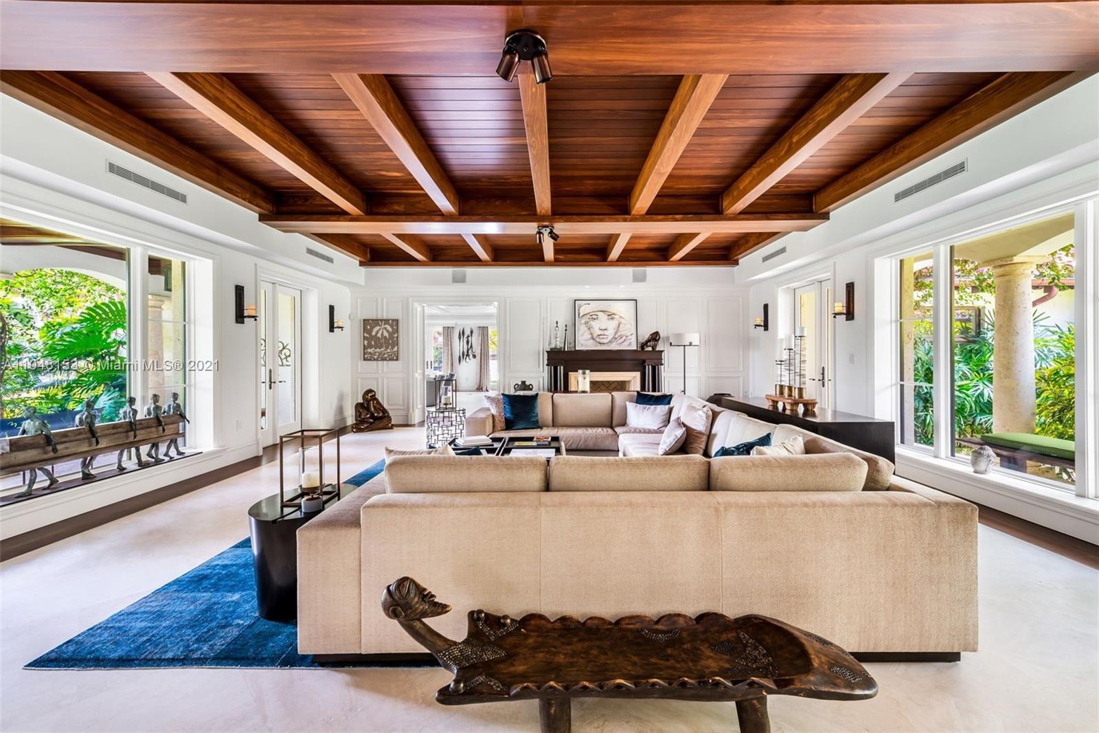 6385 Pine Tree Dr Circle Miami Beach, FL 33140 - Photo 10 of 37 a living room with furniture a flat screen tv and a large window