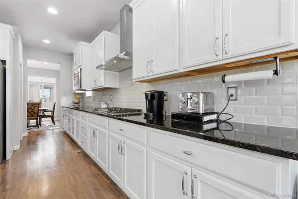 a kitchen with granite countertop a sink a stove and cabinets