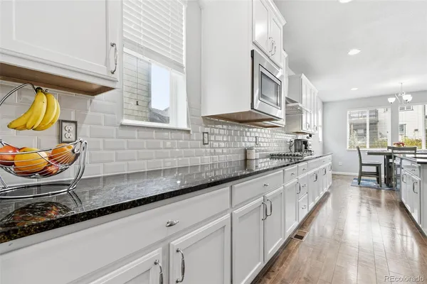 a kitchen with stainless steel appliances granite countertop a sink a stove cabinets counter space and a window