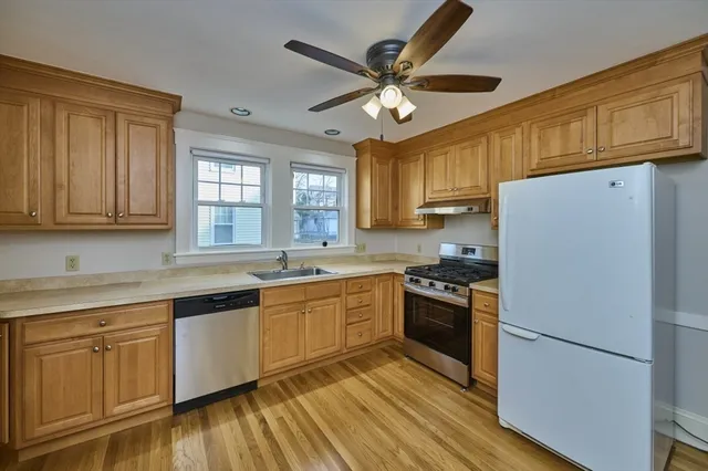 a kitchen with cabinets stainless steel appliances a sink and a window