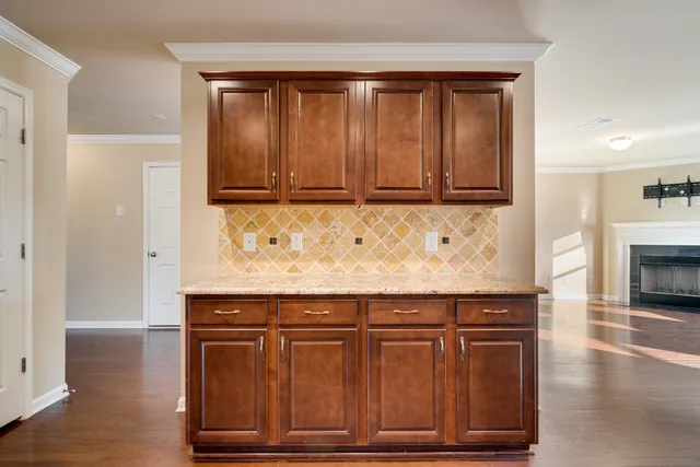 a large kitchen with stainless steel appliances granite countertop lots of counter top space and wooden floors