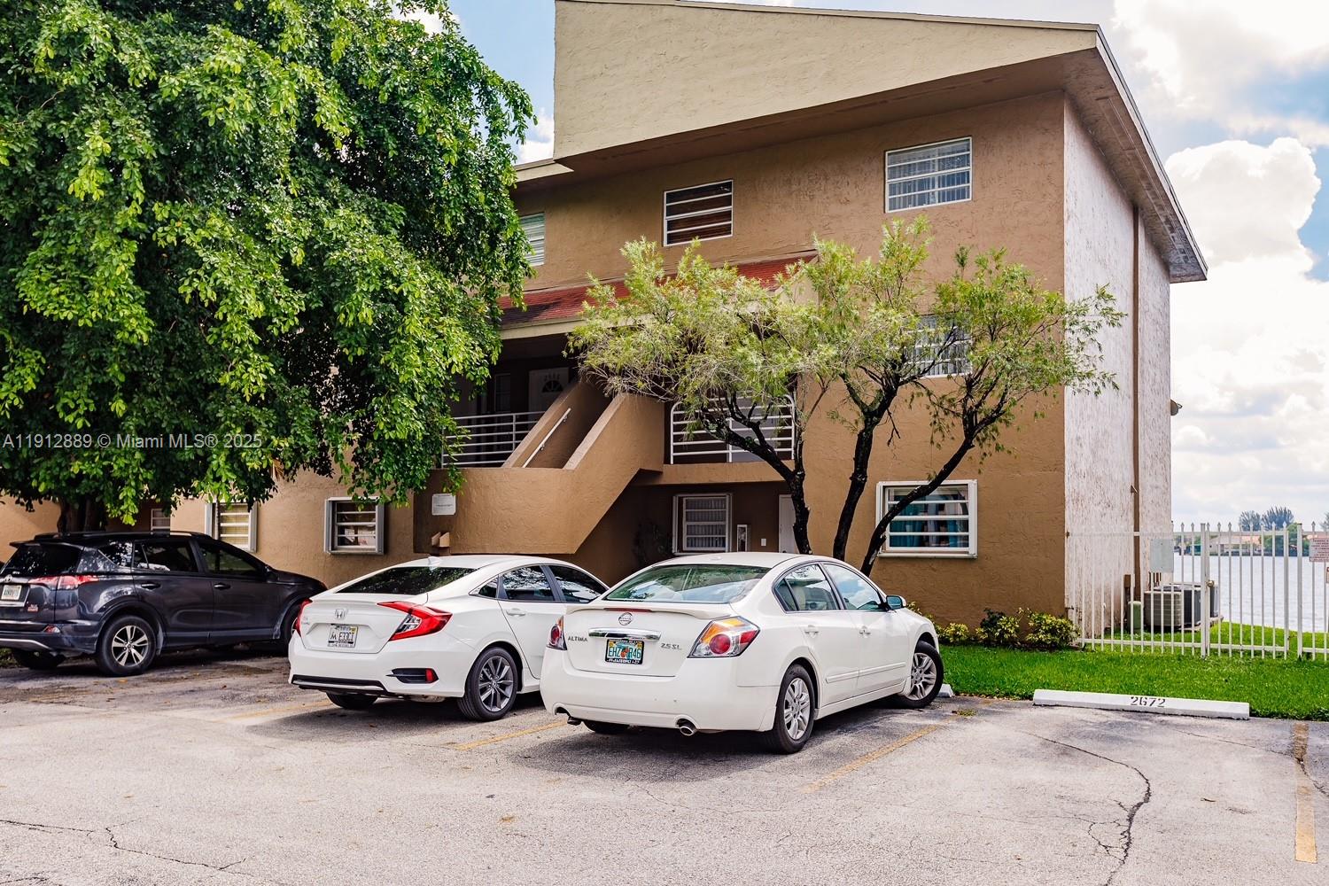 2670 West 60th Street, Unit 90 Hialeah, FL 33016 - Photo 2 of 26 a white car parked in front of a house