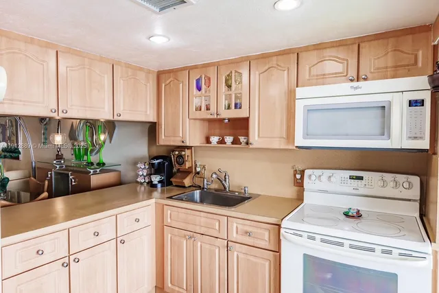 a kitchen with cabinets a center island stainless steel appliances and a counter space