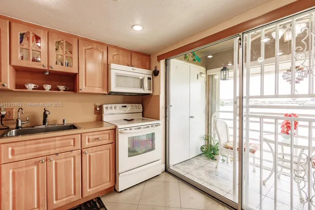 a kitchen with granite countertop a stove a sink and a refrigerator