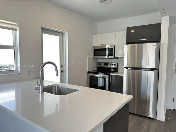 a kitchen with a refrigerator and a sink
