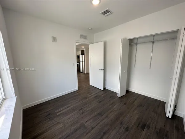 an empty room with wooden floor and closet