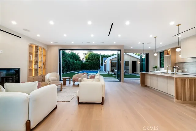 a living room with fireplace furniture and a large window