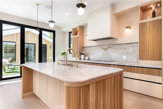 a view of kitchen island a sink appliances and a counter top space