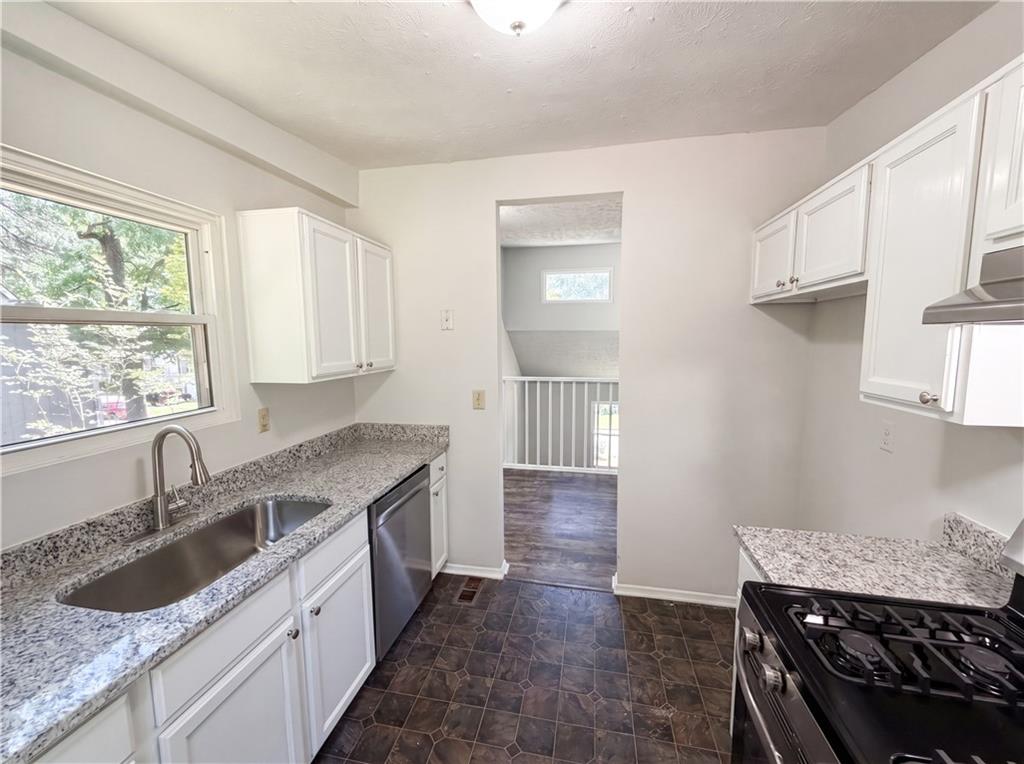 6830 Earlhurst Road Atlanta, GA 30349 - Photo 9 of 27 a kitchen with granite countertop a sink stove and cabinets