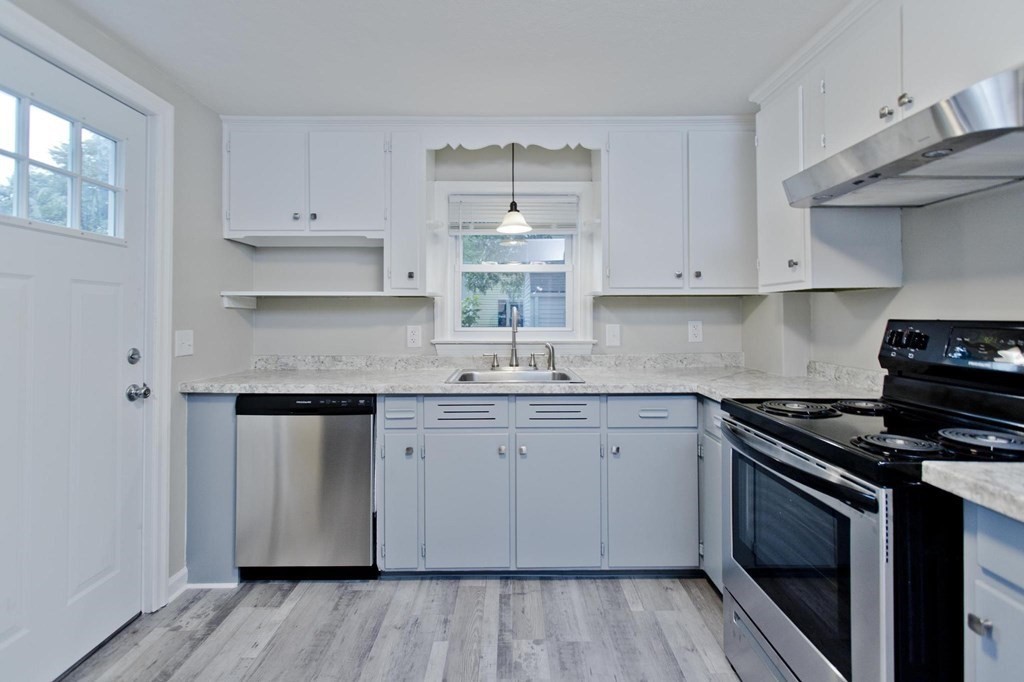 228 Shawmut Street Springfield, MA 01108 - Photo 3 of 39 a kitchen with granite countertop white cabinets and a stove with wooden floor