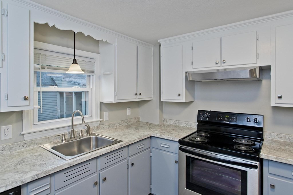 228 Shawmut Street Springfield, MA 01108 - Photo 5 of 39 a kitchen with granite countertop a sink a stove and cabinets