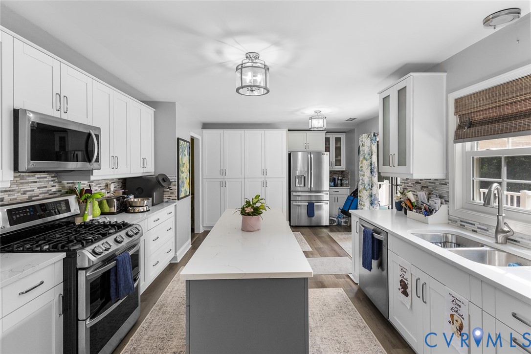 212 Copper Line Road Bumpass, VA 23024 - Photo 8 of 35 a large kitchen with stainless steel appliances a stove a sink dishwasher a microwave oven and a refrigerator