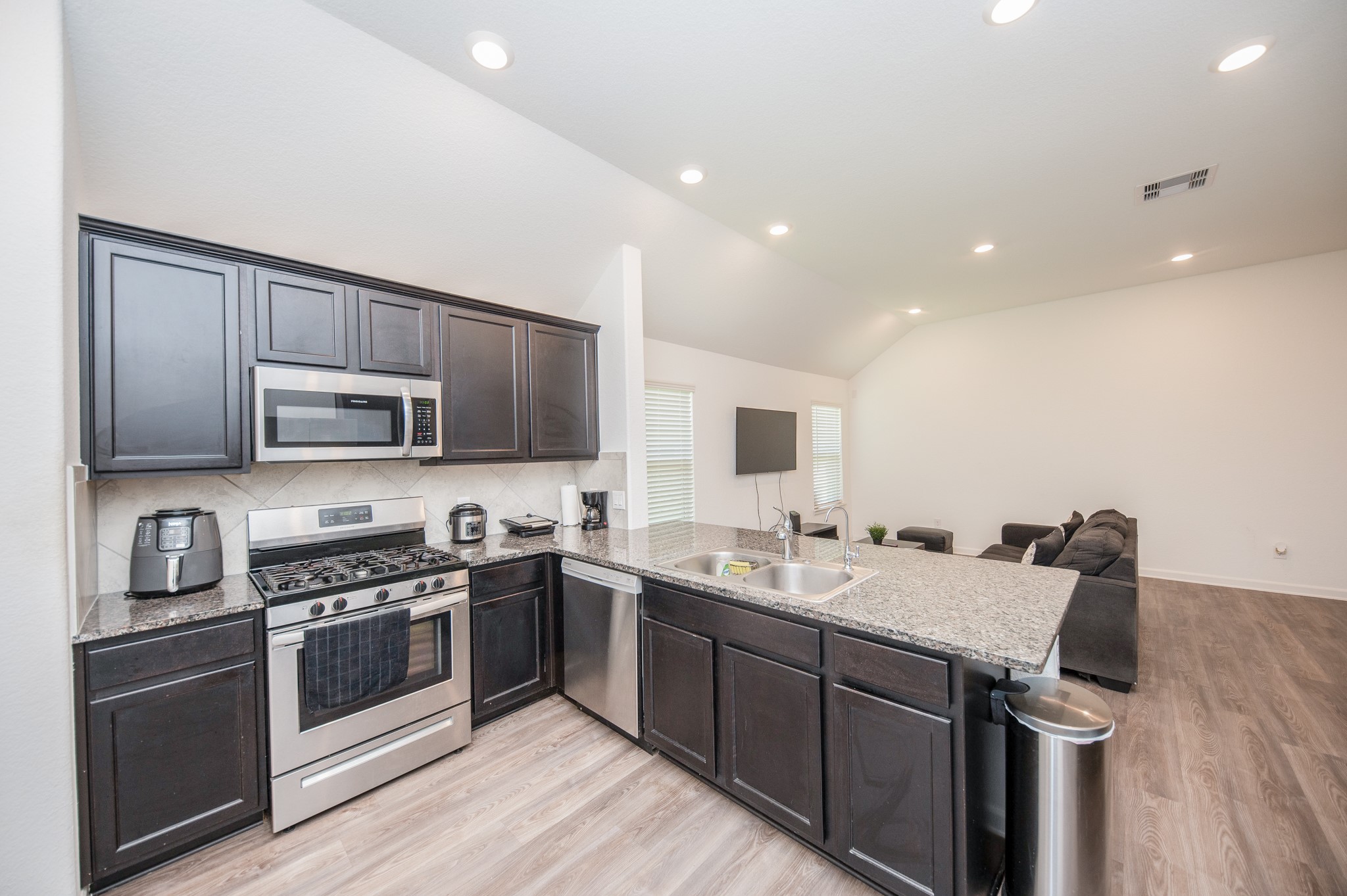 3634 Homestead Ridge Lane Richmond, TX 77406 - Photo 11 of 32 a kitchen with stainless steel appliances granite countertop a sink a stove top oven and wooden floors