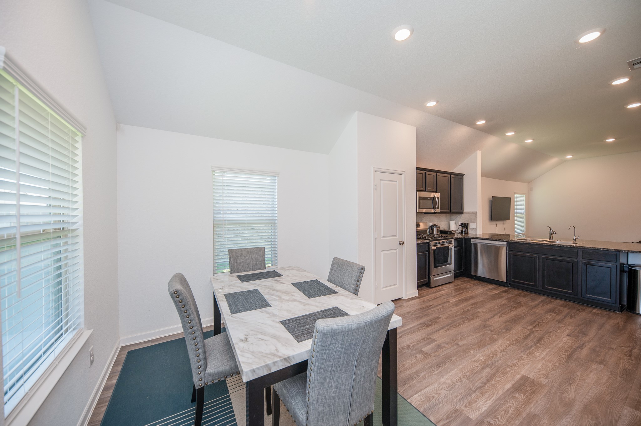3634 Homestead Ridge Lane Richmond, TX 77406 - Photo 13 of 32 a kitchen with stainless steel appliances kitchen island granite countertop a sink table and chairs