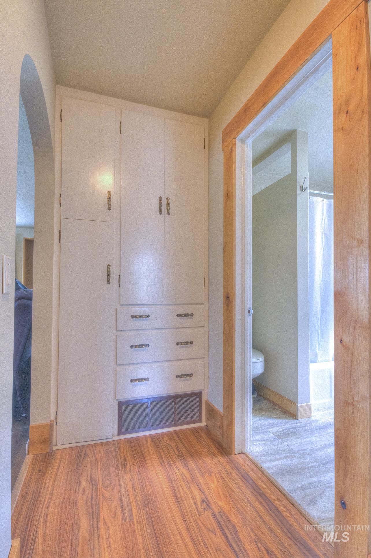 351 West Main Street South Vale, OR 97918 - Photo 19 of 33 Built-in storage cabinetry with multiple drawers and upper cabinets, complemented by wood-finish flooring and a wood-trimmed doorway