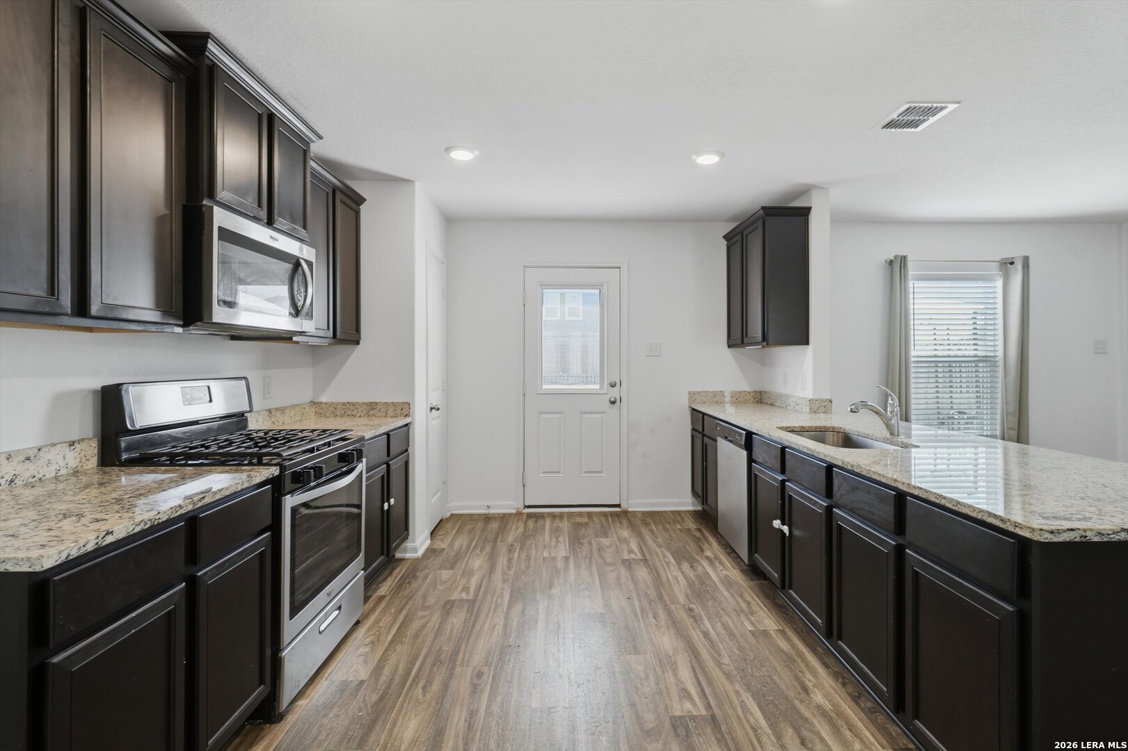 3130 Jackson Converse, TX 78109 - Photo 10 of 22 a kitchen with stainless steel appliances granite countertop wooden cabinets a stove top oven a sink and dishwasher