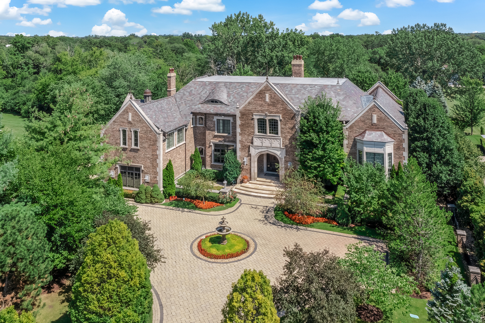a view of a white house with a big yard and potted plants