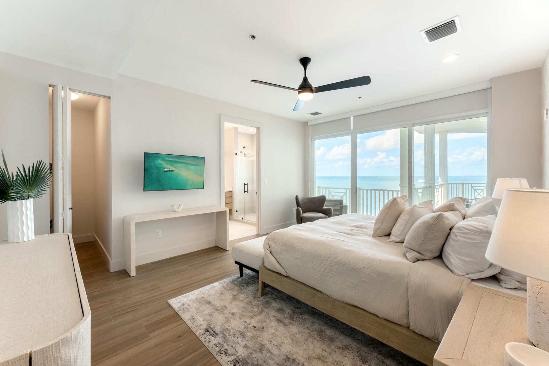 104000 Overseas Highway, Unit 5 Key Largo, FL 33037 - Photo 15 of 60 a bedroom with a large bed and a flat screen tv