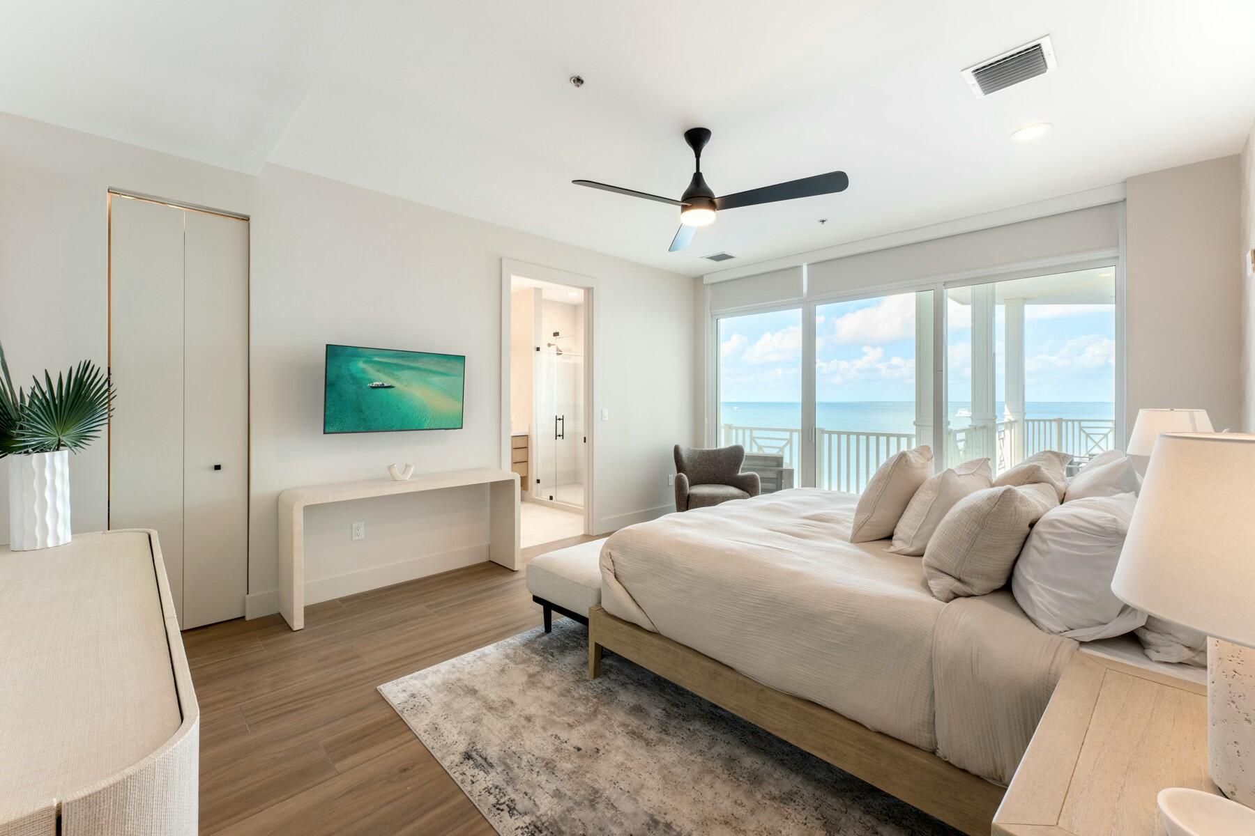 104000 Overseas Highway, Unit 5 Key Largo, FL 33037 - Photo 16 of 60 a bedroom with a large bed and a flat screen tv