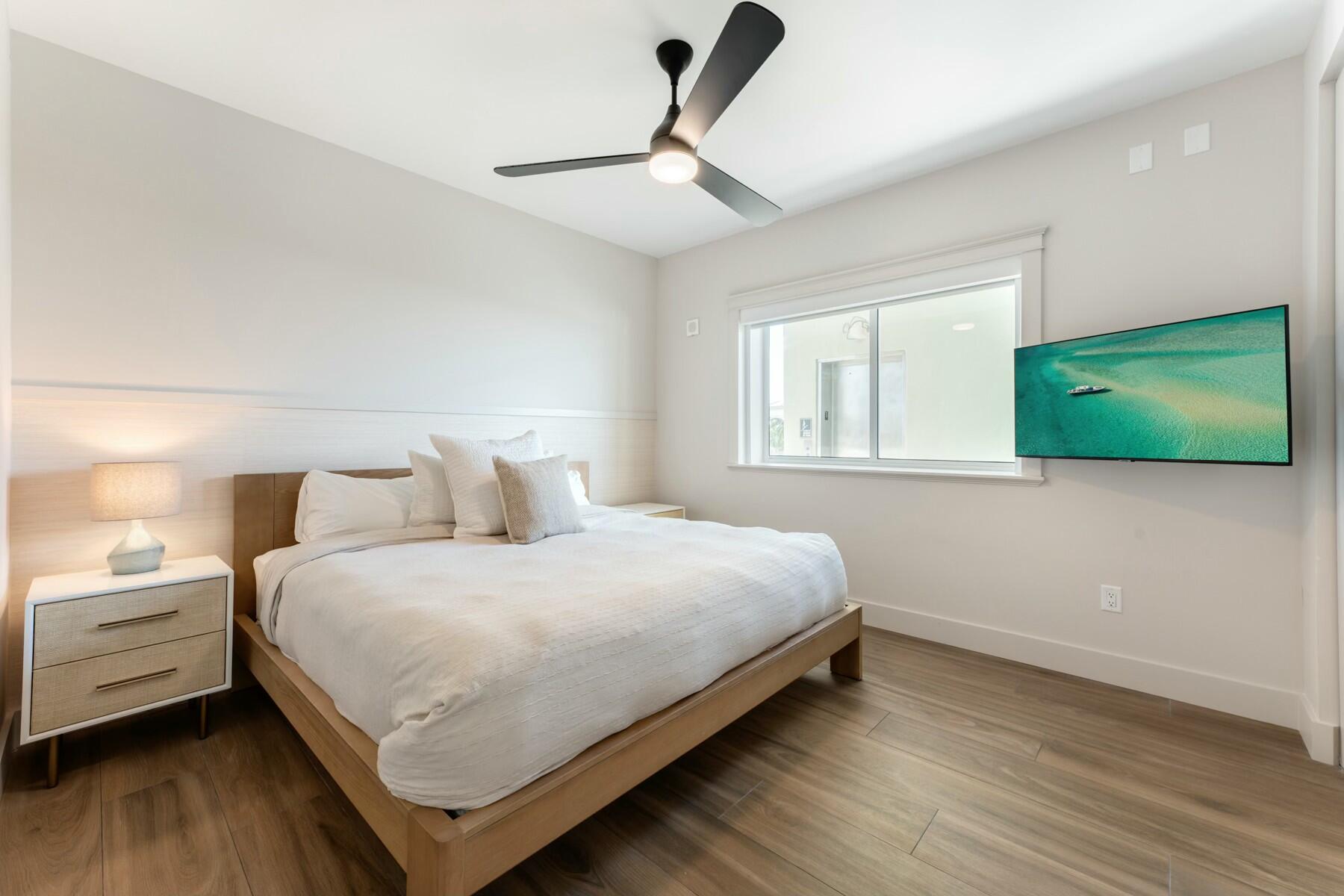 104000 Overseas Highway, Unit 5 Key Largo, FL 33037 - Photo 19 of 60 a bedroom with a bed and a flat tv screen on dresser