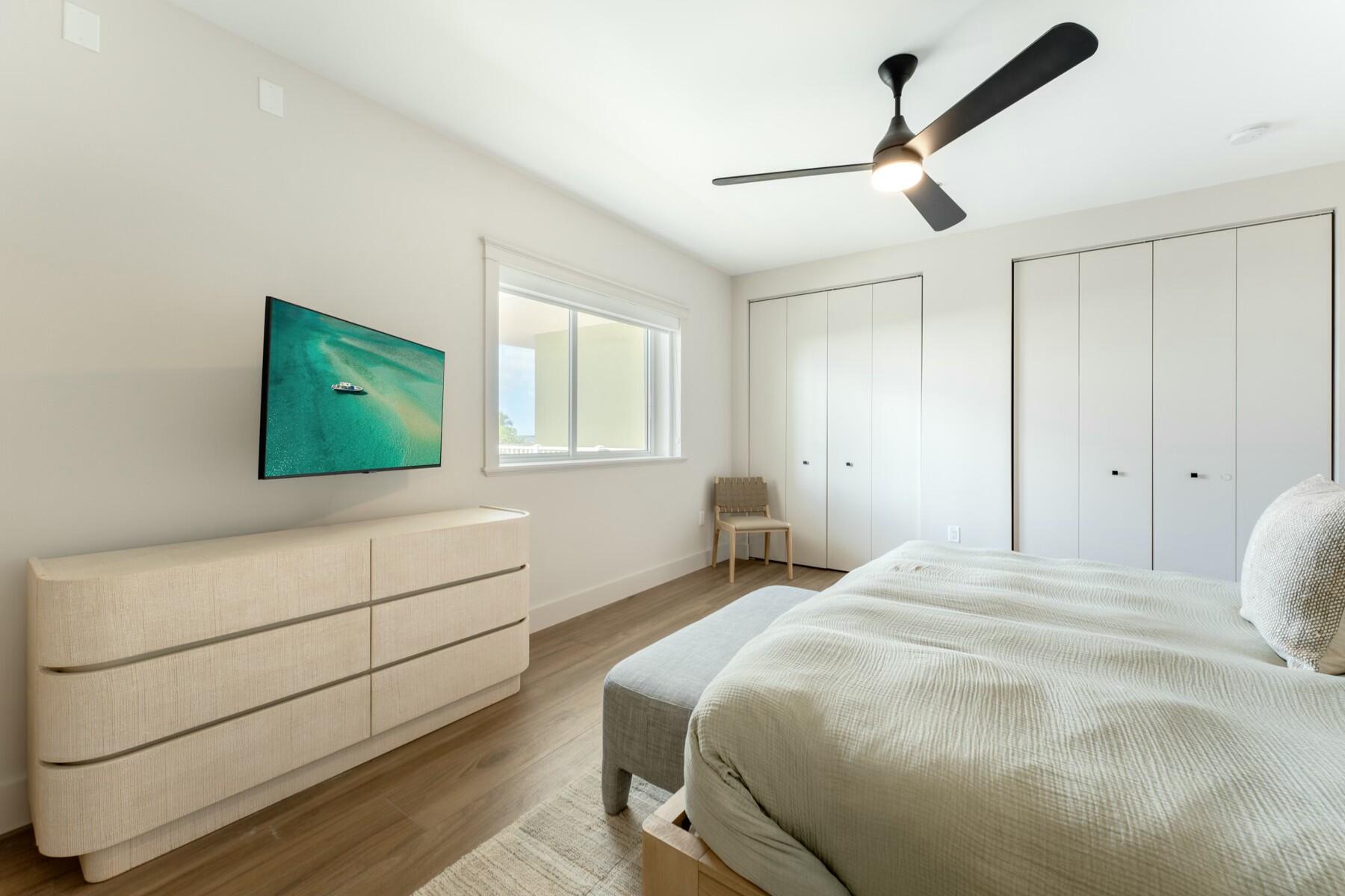 104000 Overseas Highway, Unit 5 Key Largo, FL 33037 - Photo 21 of 60 a bedroom with a bed and a flat tv screen on dresser