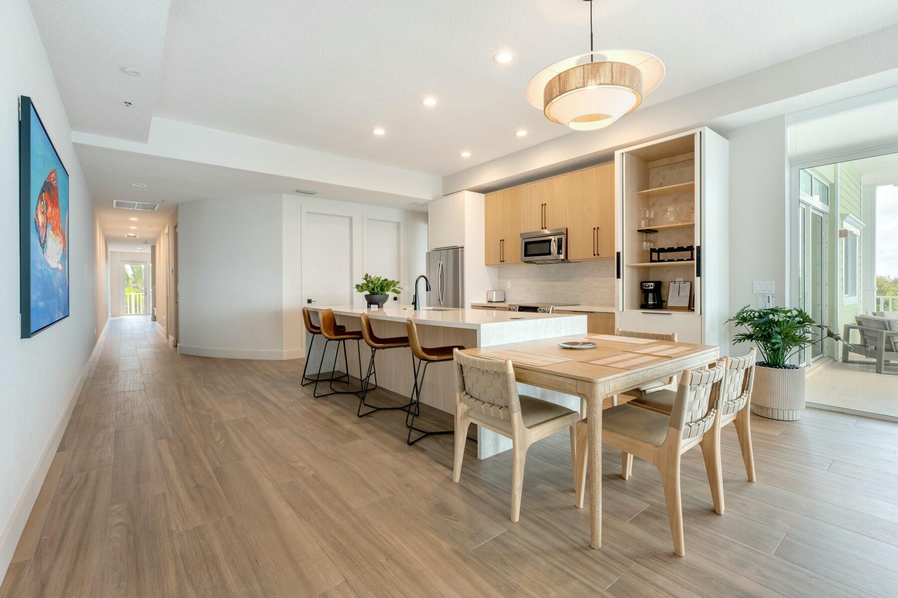 104000 Overseas Highway, Unit 5 Key Largo, FL 33037 - Photo 3 of 60 a view of a dining room with furniture and wooden floor