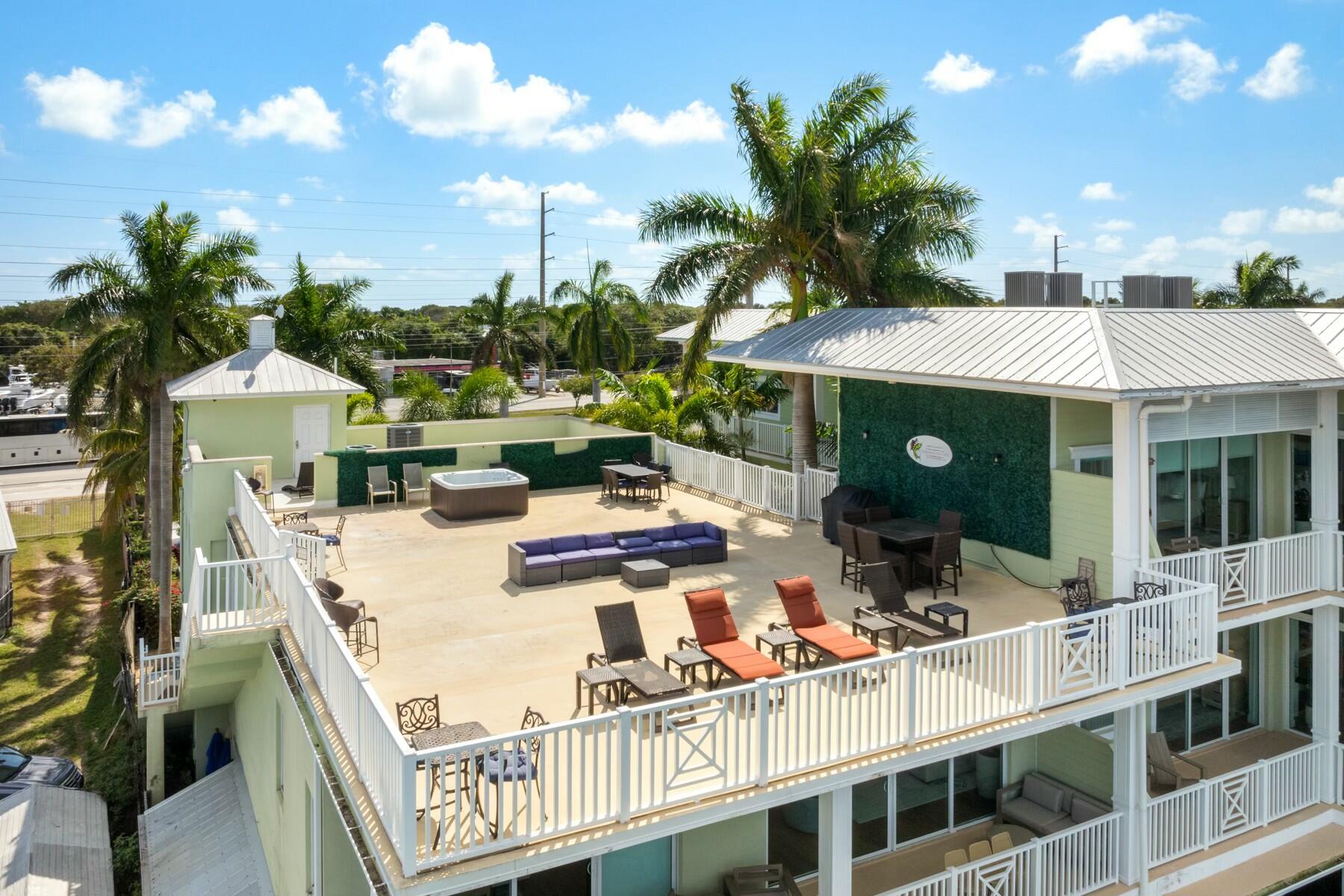 104000 Overseas Highway, Unit 5 Key Largo, FL 33037 - Photo 38 of 60 a view of a patio with dining table and chairs with a barbeque grill and plants