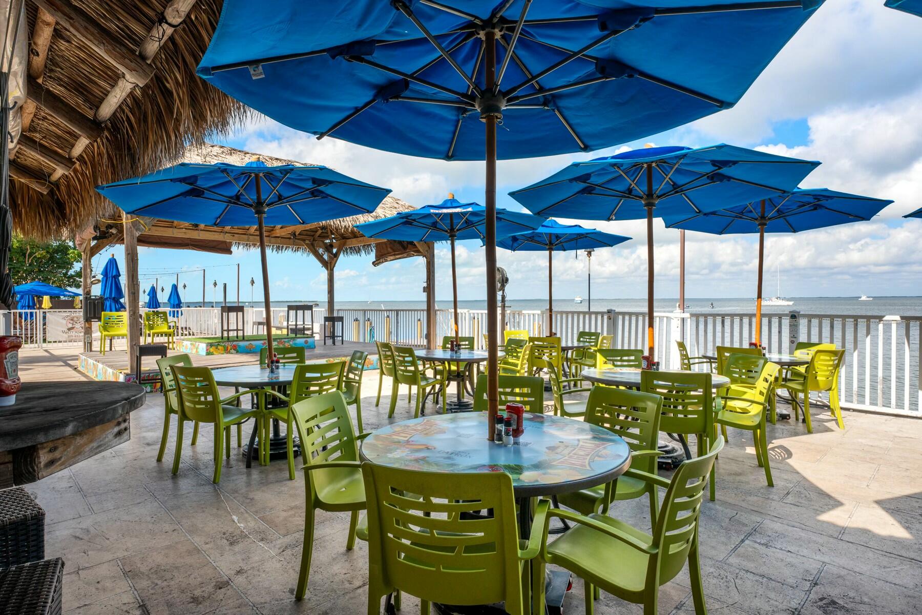 104000 Overseas Highway, Unit 5 Key Largo, FL 33037 - Photo 46 of 60 a view of patio with chairs and table under an umbrella
