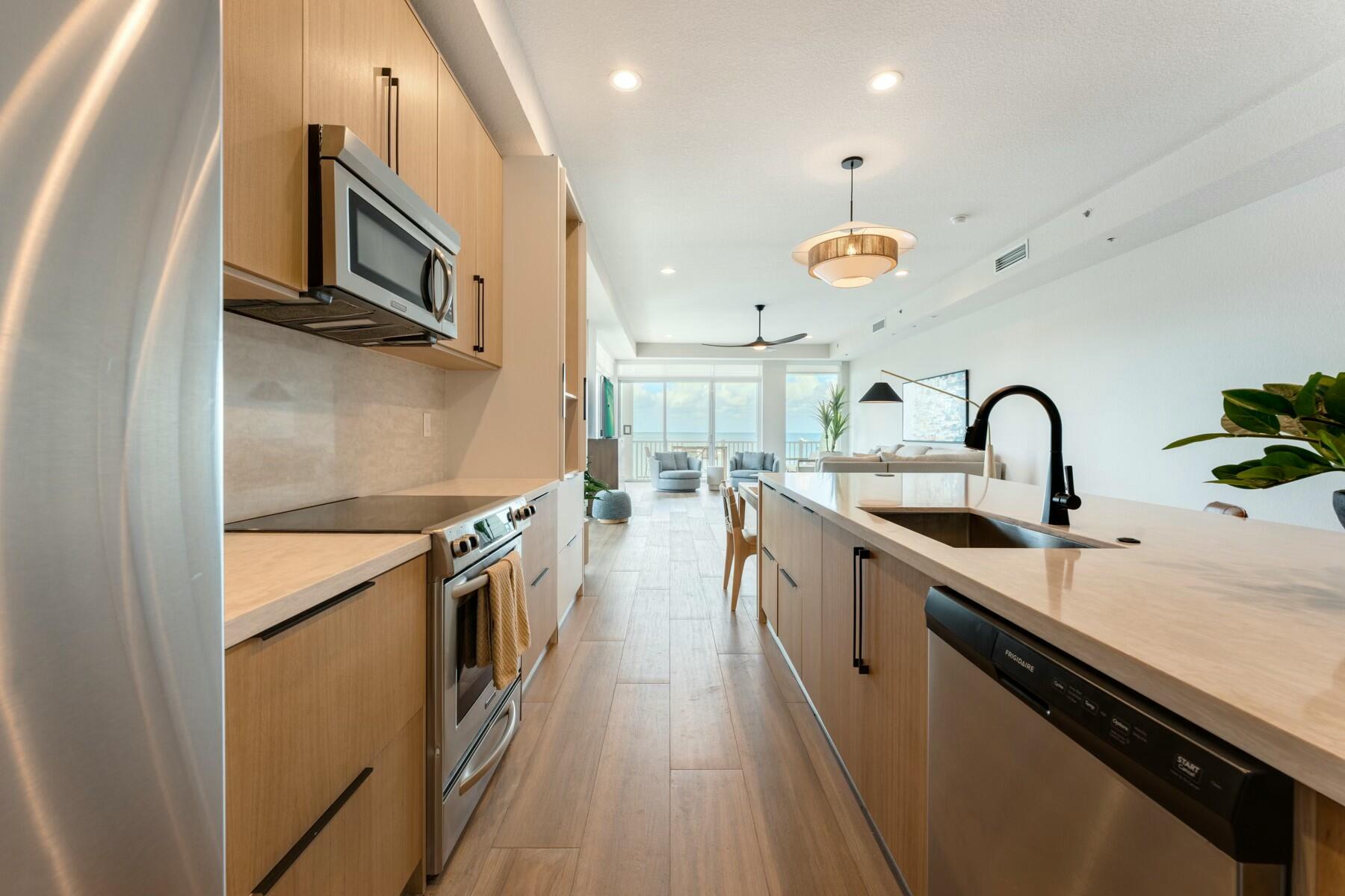 104000 Overseas Highway, Unit 5 Key Largo, FL 33037 - Photo 5 of 60 a kitchen with stainless steel appliances granite countertop a sink a stove and a wooden floors