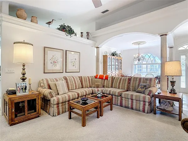 a dining room with furniture a book shelves and a chandelier