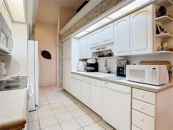 a kitchen with white cabinets and appliances