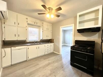 2315 15th Street Lubbock, TX 79401 - Photo 5 of 10 a kitchen with granite countertop a stove a sink and a refrigerator