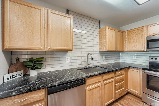 a kitchen with granite countertop cabinets sink and window