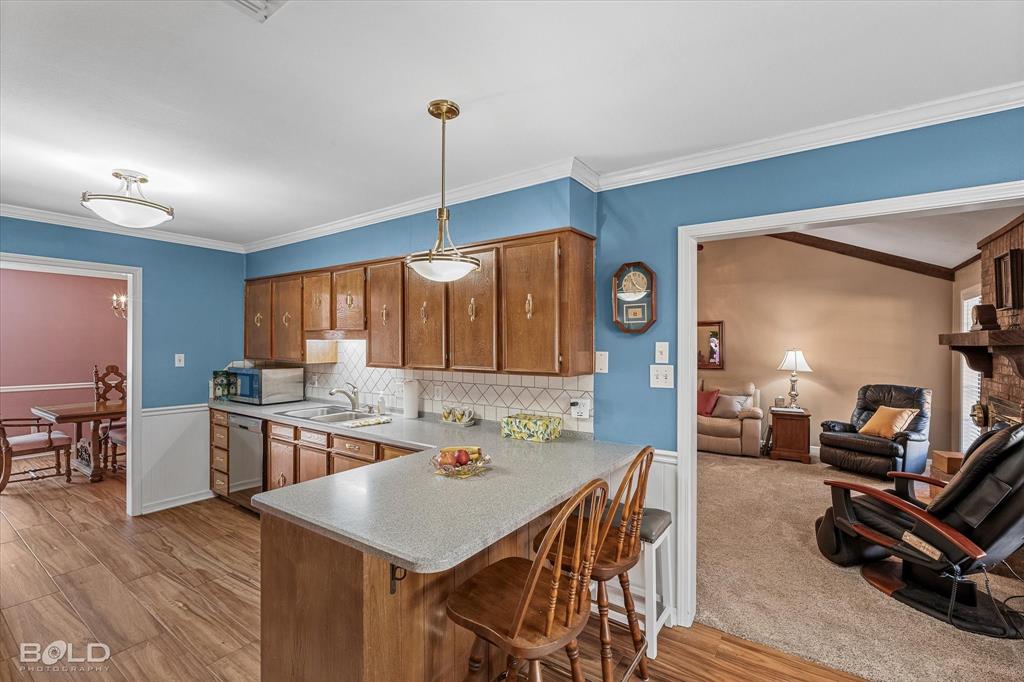 8543 Sac Fox Road Shreveport, LA 71107 - Photo 20 of 35 a kitchen with stainless steel appliances kitchen island granite countertop a stove a sink a dining table and chairs with wooden floor