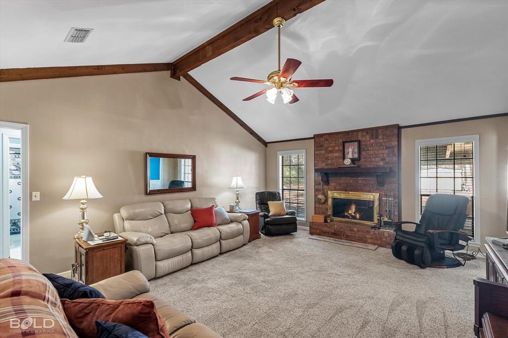 8543 Sac Fox Road Shreveport, LA 71107 - Photo 27 of 35 a living room with furniture a fireplace and a flat screen tv