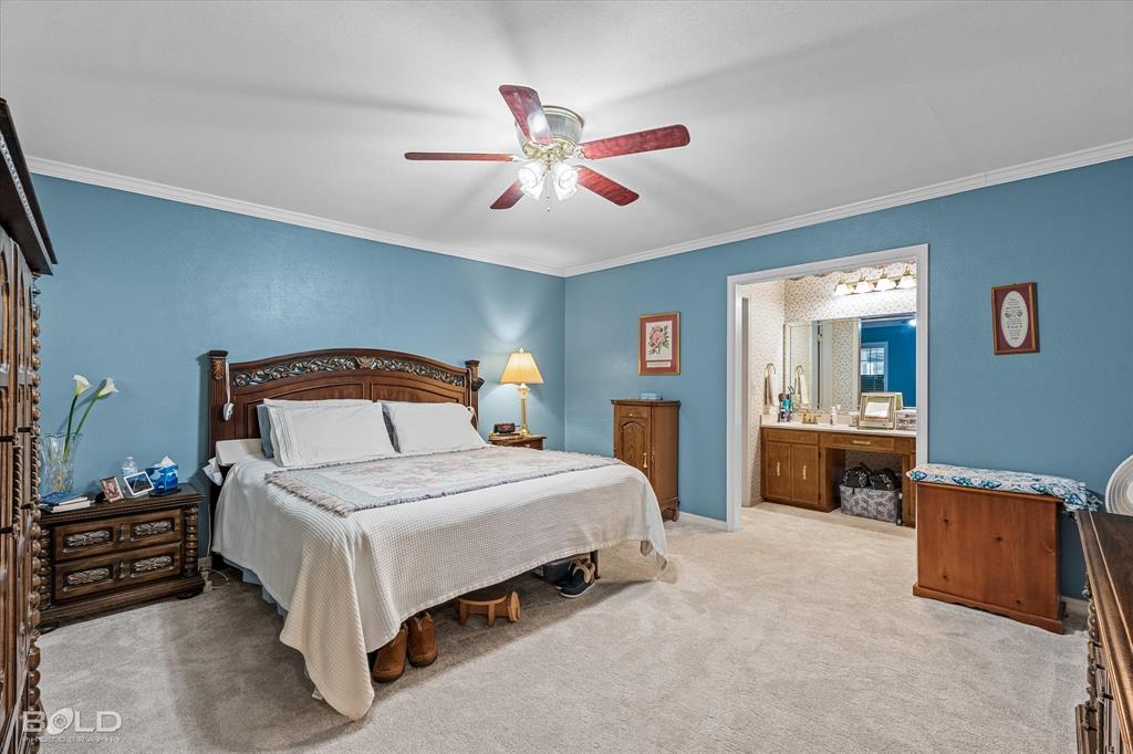 8543 Sac Fox Road Shreveport, LA 71107 - Photo 28 of 35 a bedroom with a bed and a chandelier