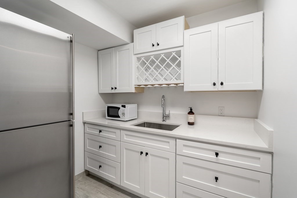 89 University Road Brookline, MA 02445 - Photo 29 of 41 a kitchen with white cabinets and white appliances