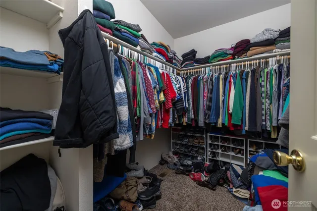 a view of walk in closet with clothes and shoes