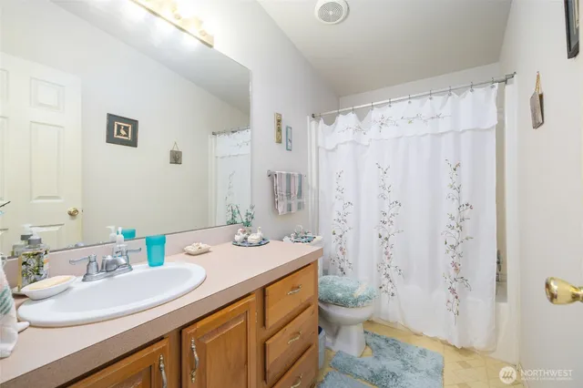 a bathroom with a double vanity sink toilet and shower