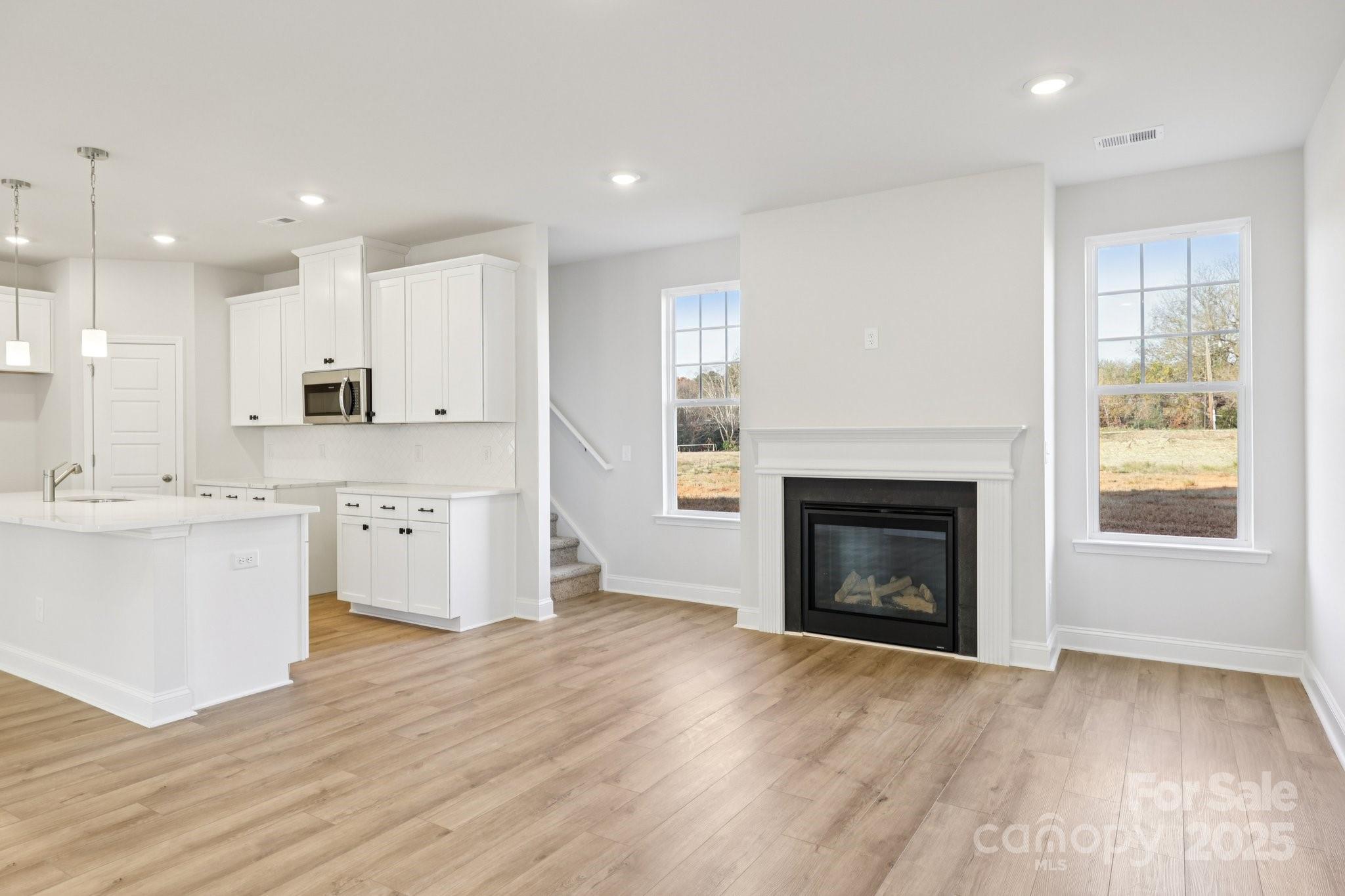9612 Pointer Road, Unit 59 Huntersville, NC 28078 - Photo 9 of 43 a large kitchen with a refrigerator a stove top oven a sink and a fireplace