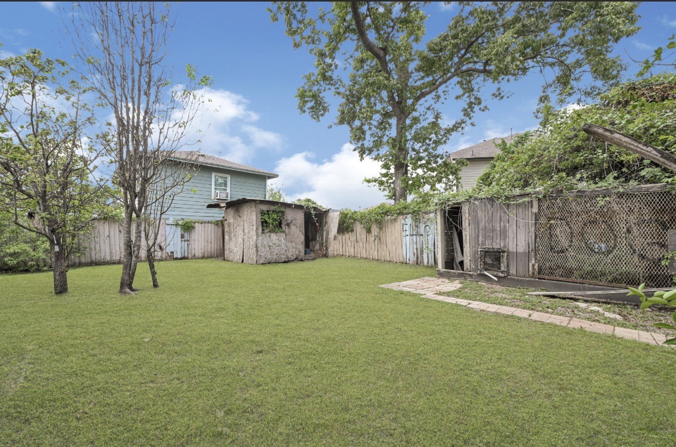 209 Frawley Street Houston, TX 77009 - Photo 12 of 21 a backyard of house with a slide and large trees