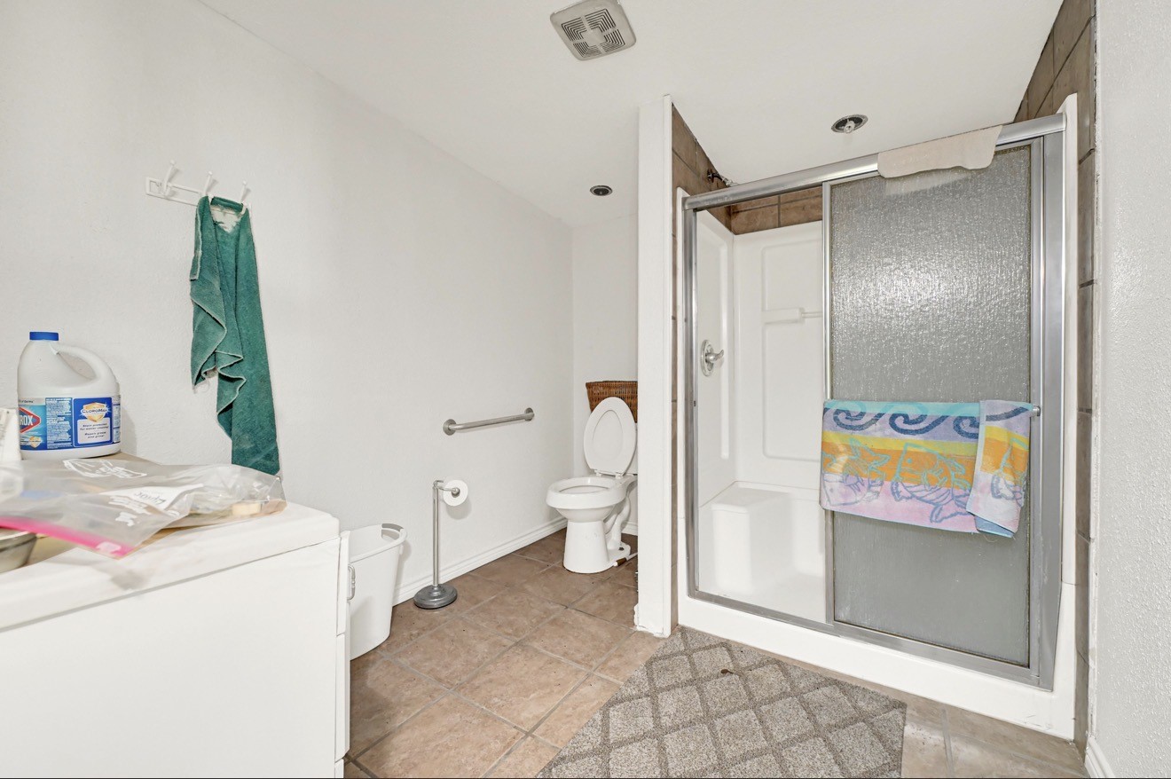 209 Frawley Street Houston, TX 77009 - Photo 14 of 21 a bathroom with a granite countertop sink a toilet and a shower