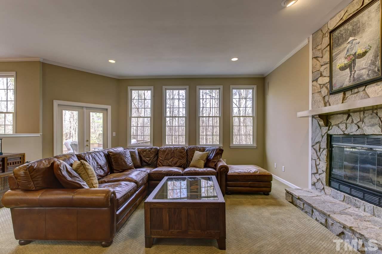 12312 Galway Drive Raleigh, NC 27613 - Photo 3 of 25 Cozy up next to the stone front fireplace in the family room or enjoy the wooded views from the wall of windows.