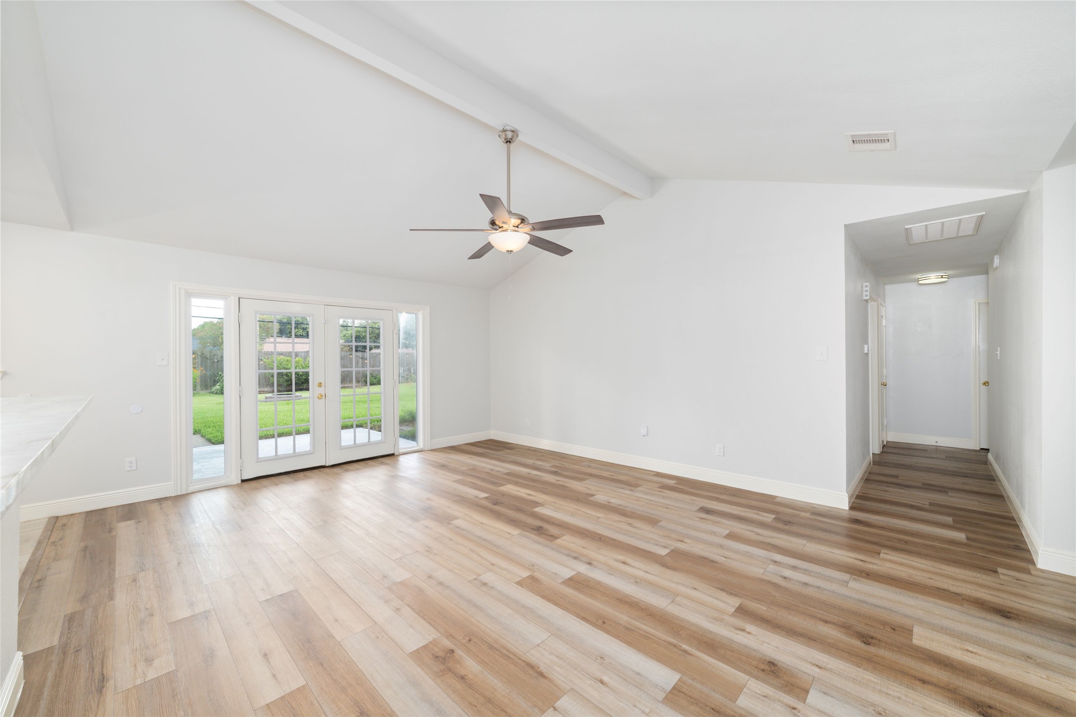 5922 Hummingbird Street Houston, TX 77096 - Photo 7 of 26 This living room absolutely delivers. Soaring vaulted ceilings, wide-open living spaces, beautiful new flooring, and French doors that spill out to the covered patio and oversized backyard create the effortless indoor-outdoor lifestyle buyers are searching for.