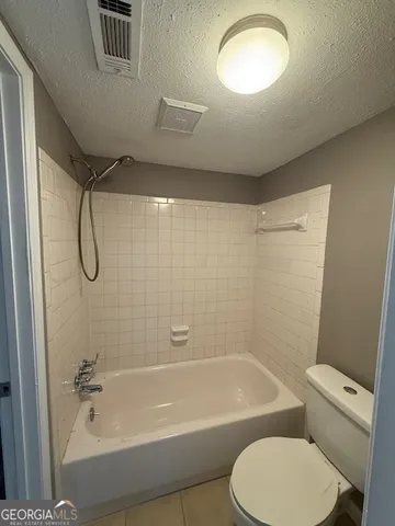 a bathroom with a toilet and a bath tub