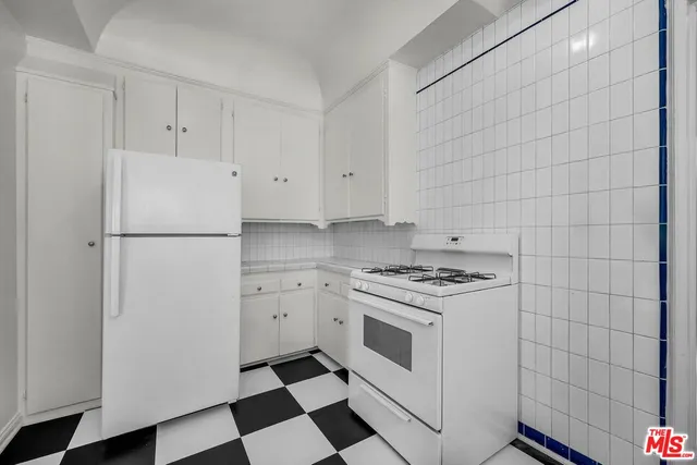 a white refrigerator freezer and a stove sitting inside of kitchen