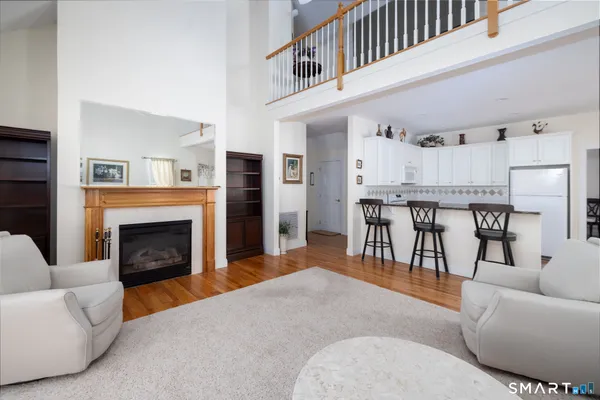 a living room with furniture a fireplace and kitchen view