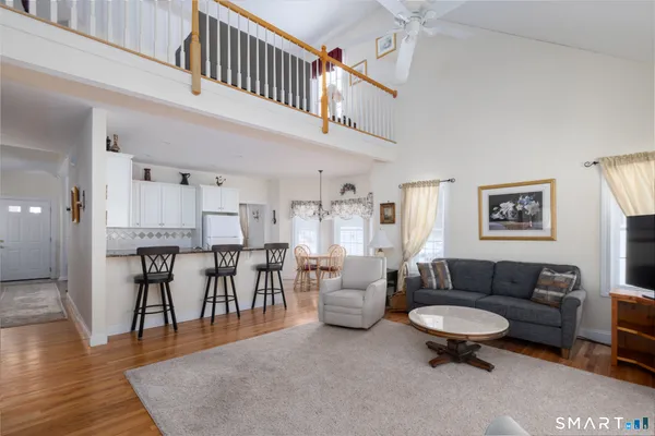 a living room with furniture and a dining table with wooden floor