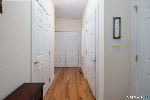 a view of a hallway with wooden floor and staircase